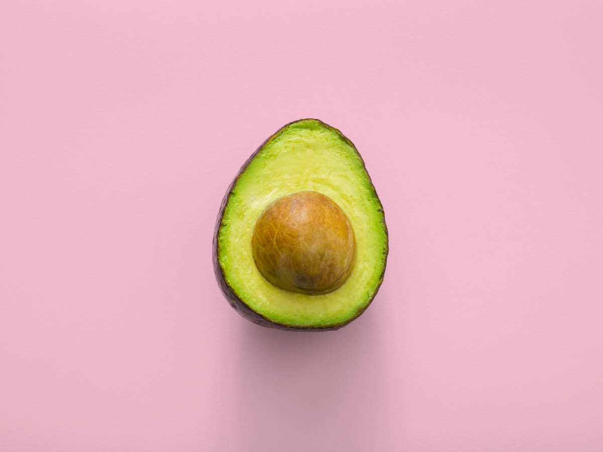 Avocado aperto su sfondo rosa