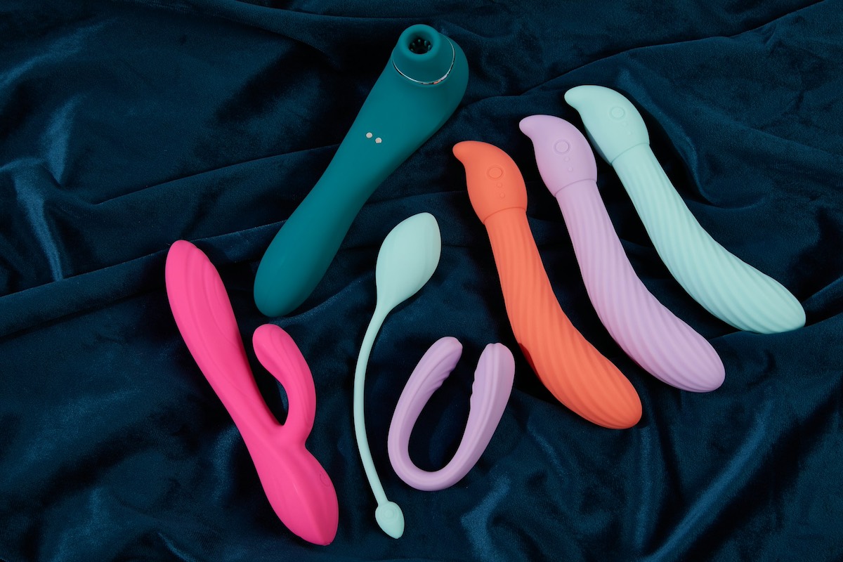 assortimento di sex toys colorati adagiati sul letto