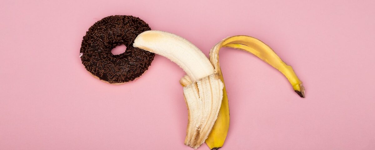 Metafora visiva di esplorazione sessuale femminile con banana su sfondo viola