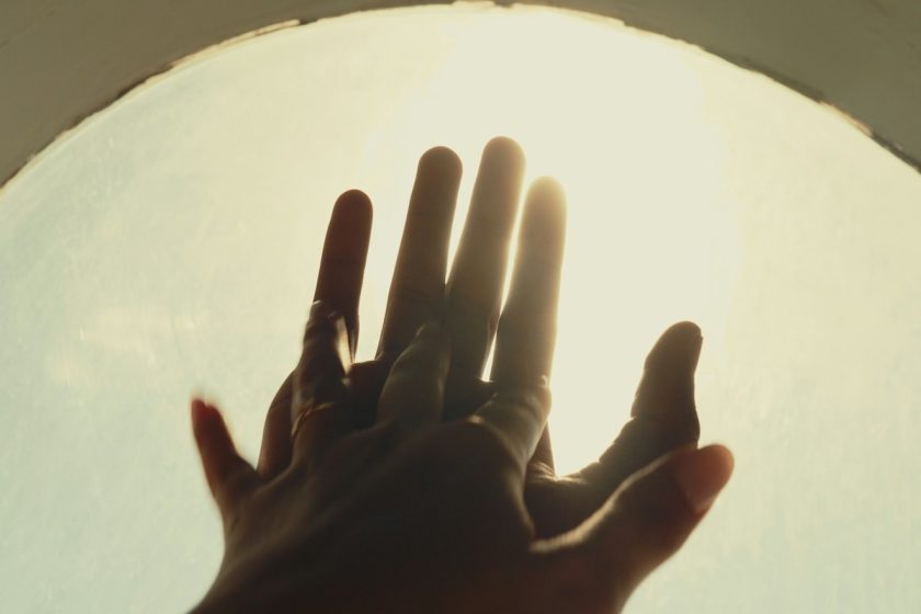 Due mani che si sfiorano in un ambiente caldo e accogliente, simbolo di complicità