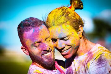 Due persone queer si guardano con complicità, rappresentando intimità e comunicazione