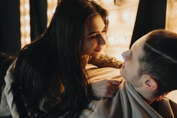 Due persone sedute vicine con mani che si sfiorano, atmosfera di intimità e rispetto