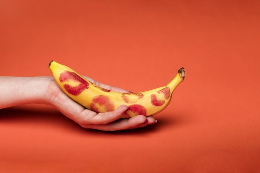 Banana gialla con impronta di rossetto rosso, immagine concettuale.