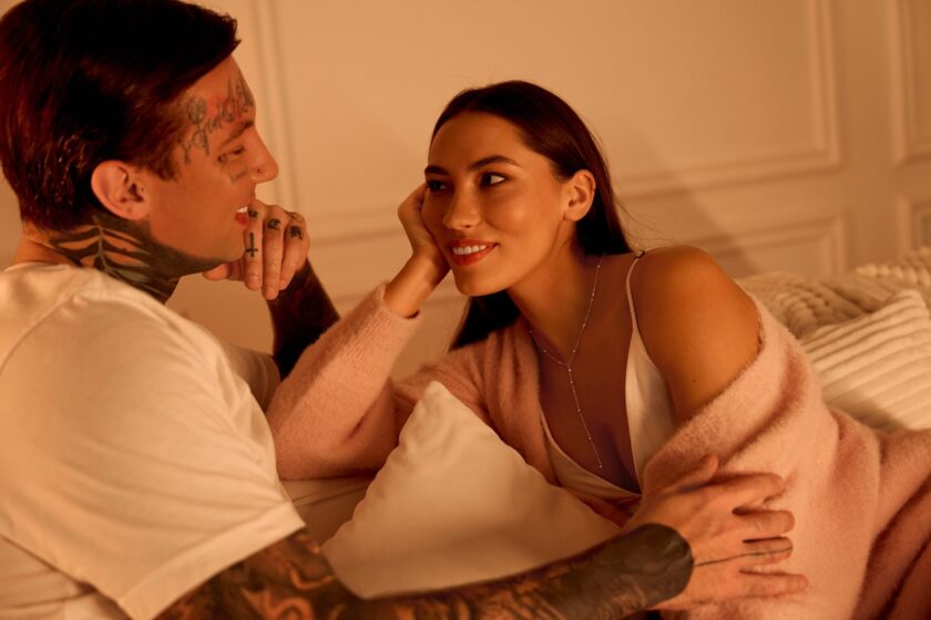 Immagine a tema sesso anale: coppia sul divano in dialogo tranquillo e intimo, luce calda e atmosfera sicura.