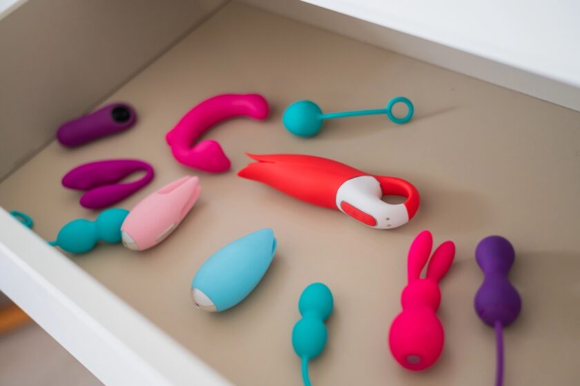 Immagine a tema sex toy: collezione di vibratori e dildo riposti in un cassetto bianco, ambiente ordinato e discreto.