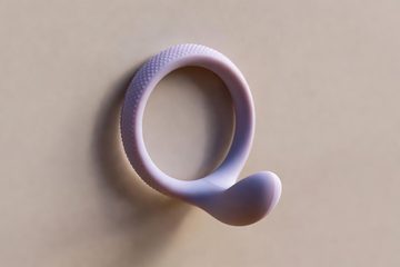 Anello vibrante nero appoggiato accanto al cavo di ricarica